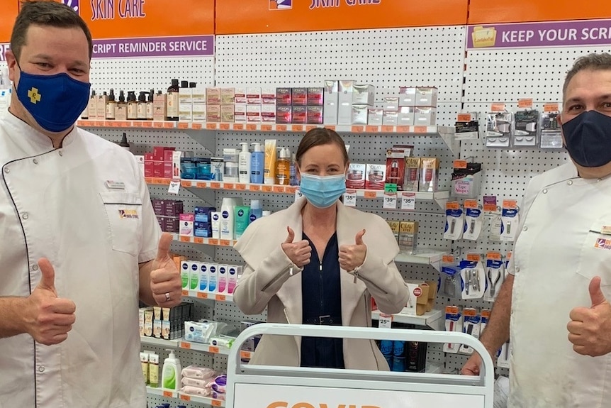 An image of Chris Owen, Yvette D'ath and George James with thumbs up at a pharmacy wearing masks