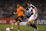 Thomas Broich passing for Roar being tackled by Adrian Leijer of Victory