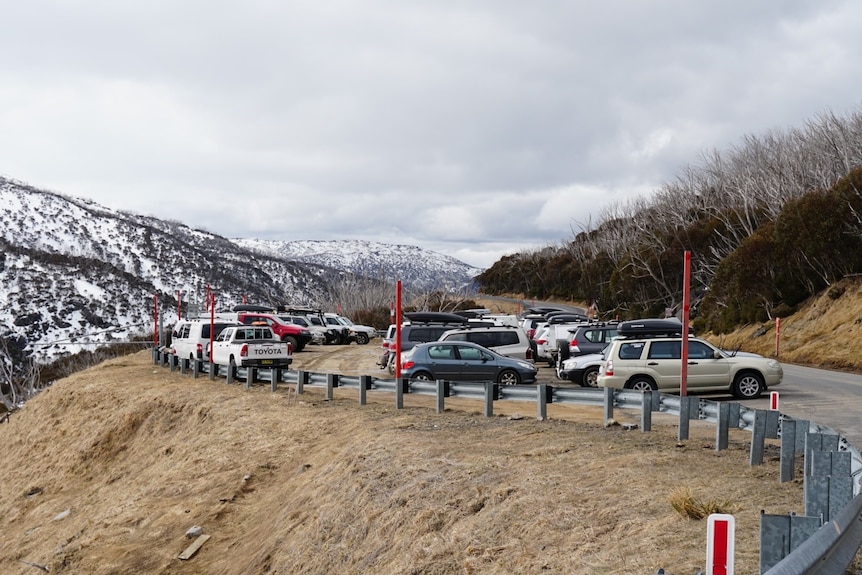 Carpark with snow capped mountains in background. 