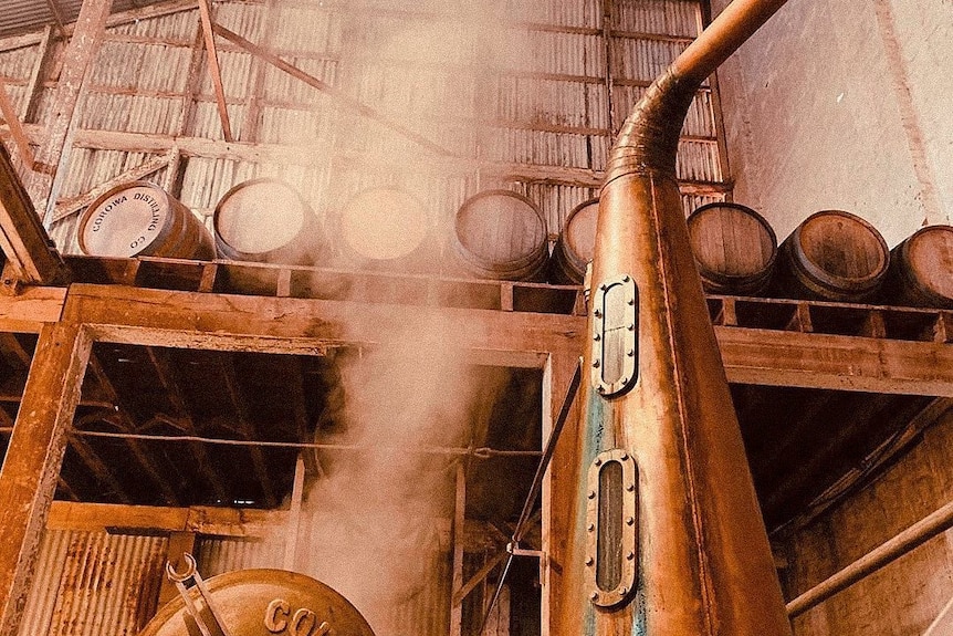 A still stands in a rustic brewing shed.