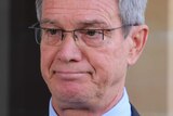 A serious looking Mike Nahan stands outside WA Parliament.