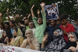 Relatives and area residents carry photographs of Zulfiqar Ali