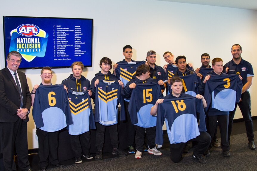 Group of football players show off their guernseys.