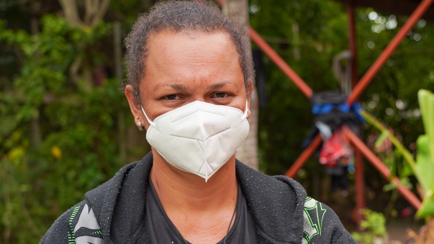 A Papua New Guinean woman in a white face mask