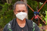 A Papua New Guinean woman in a white face mask