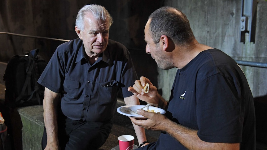 Reverend Bill Crews speaks with a man at his food van.