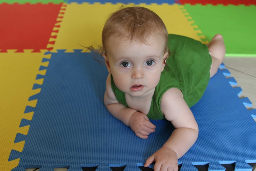 A baby looks at the camera.