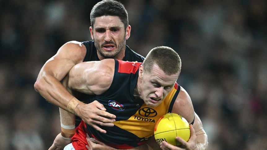 Marc Pittonet tackles Reilly O'Brien during the Blues and Crows 