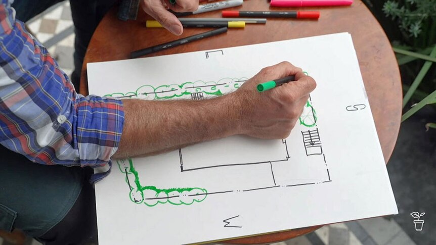 Costa drawing a sketch plan of a garden.