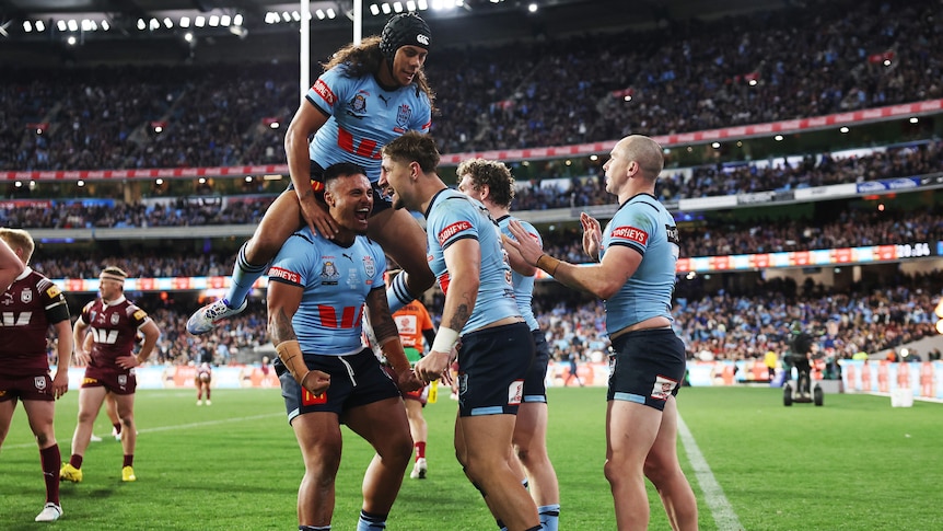 A group of players celebrate an Origin try