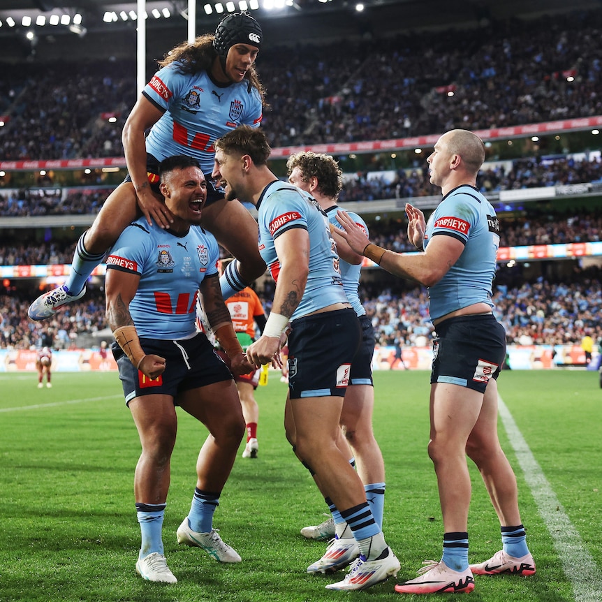 A group of players celebrate an Origin try