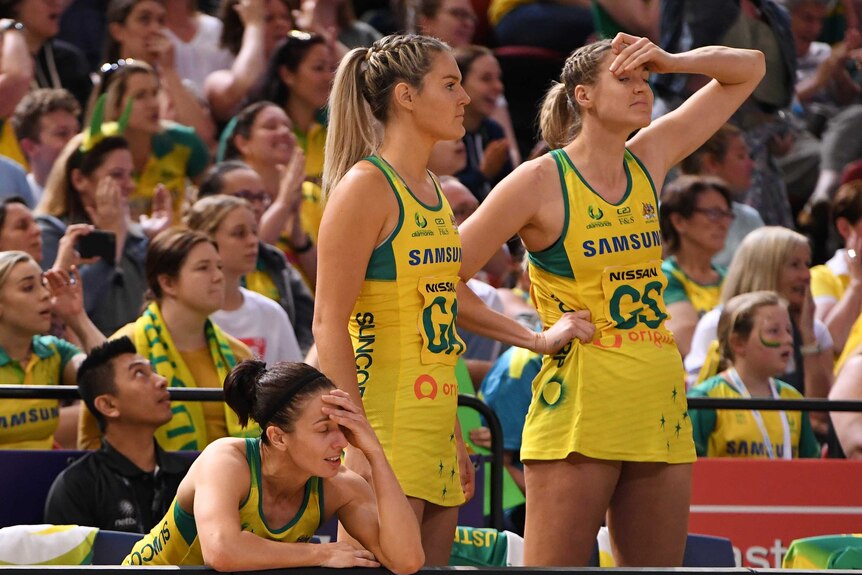A group of netball teammates grimace as they watch time run out in a loss.