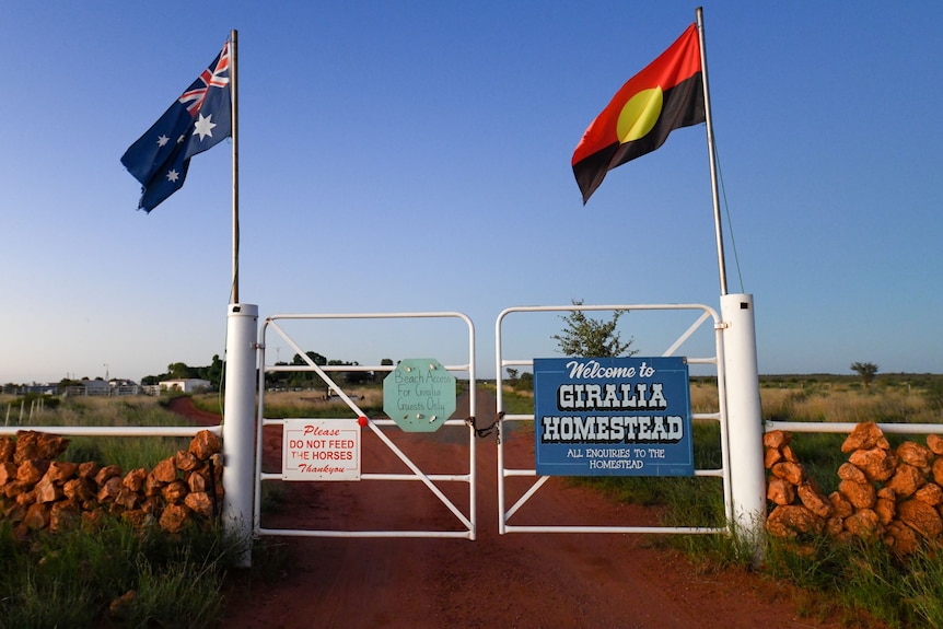Front gates of Giralia Station. There is a sign saying not to feed the horses alongside Australian and Aboriginal flag 