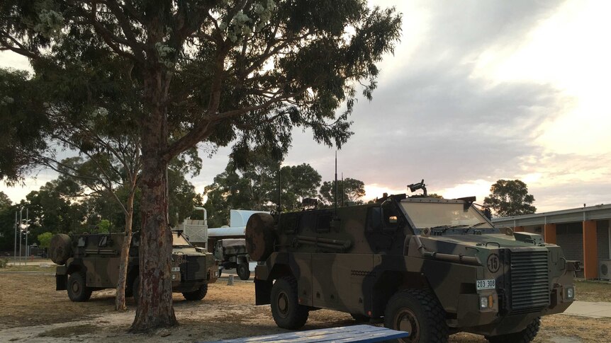 Two Army vehicles parked on the grass at Bairnsdale Secondary College.