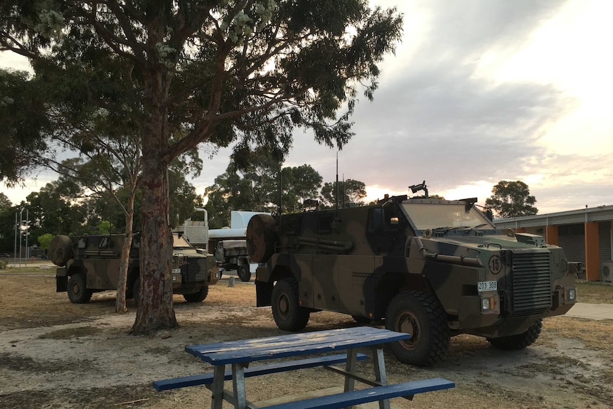 Two Army vehicles parked on the grass at Bairnsdale Secondary College.