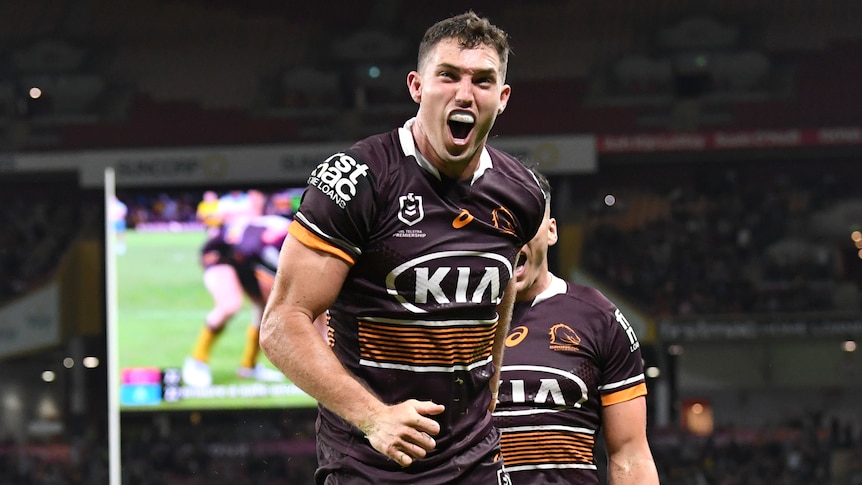 A Brisbane Broncos NRL player screams out as he celebrates a try against Gold Coast.