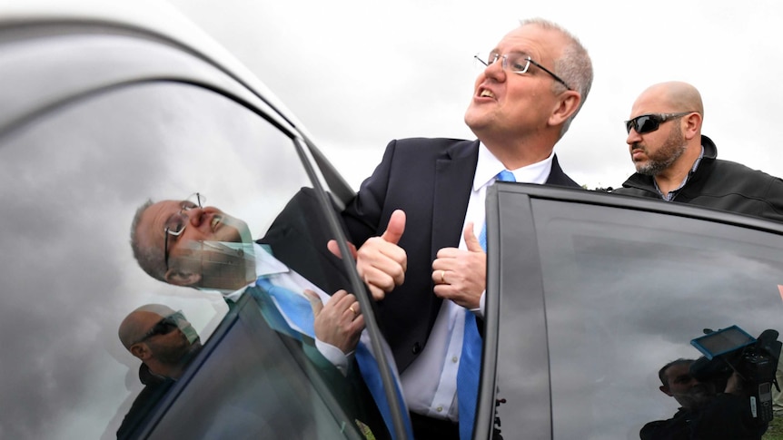 Prime Minister Scott Morrison gets into a car seat.