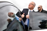 Prime Minister Scott Morrison gets into a car seat.