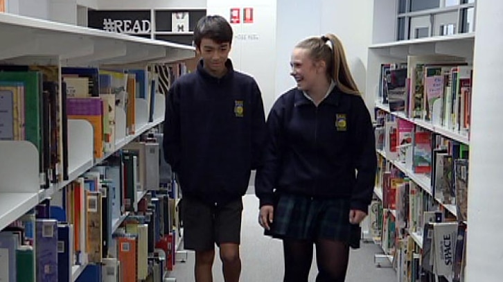 Kyi Gregory and Tori Power walk through the library.