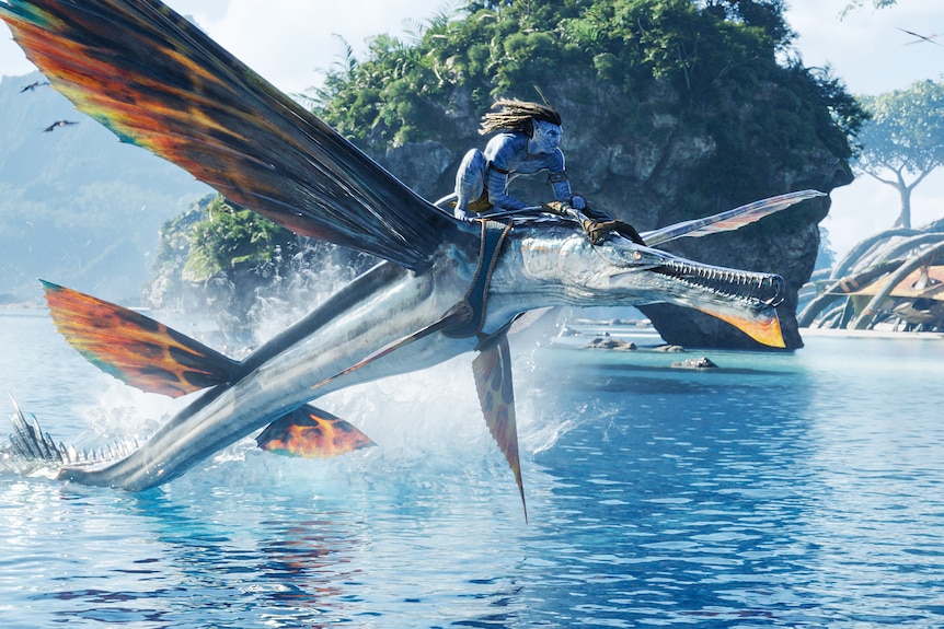 A blue alien rides a giant flying fish.