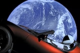 A view shows a Tesla Roadster in space with Earth in the background.
