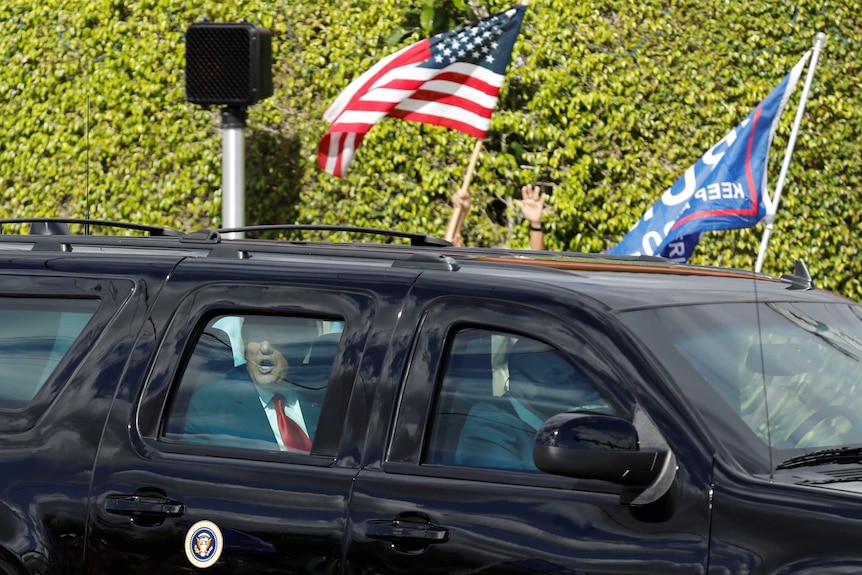 U.S. President Donald Trump reacts in a car as he drives past supporters in West Palm Beach, Florida, U.S., January 20, 2021