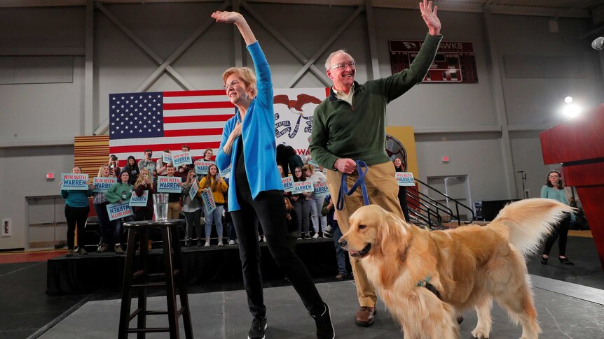 Elizabeth Warren, her husband Bruce and their dog Bailey on a stage