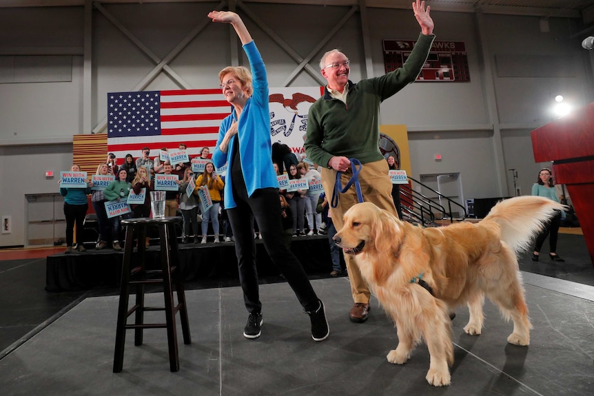 Elizabeth Warren, her husband Bruce and their dog Bailey on a stage
