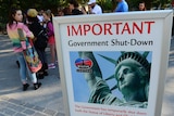 Tourists near sign saying Statue of Liberty is closed
