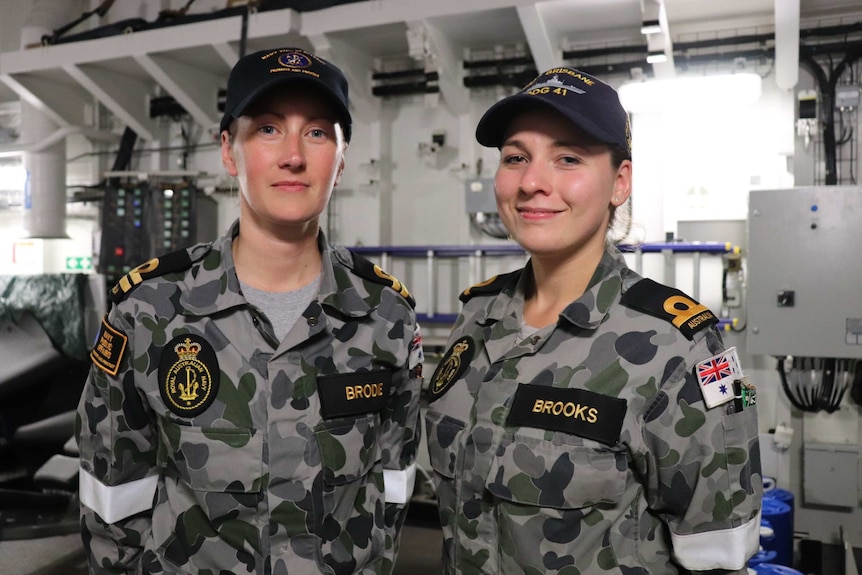 Lieutenant Danielle Brodie and Sub Lieutenant Meeka Brooks stands on HMAS Brisbane.