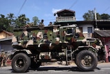 Sri Lankan army soldiers look on from an armed personnel carrier