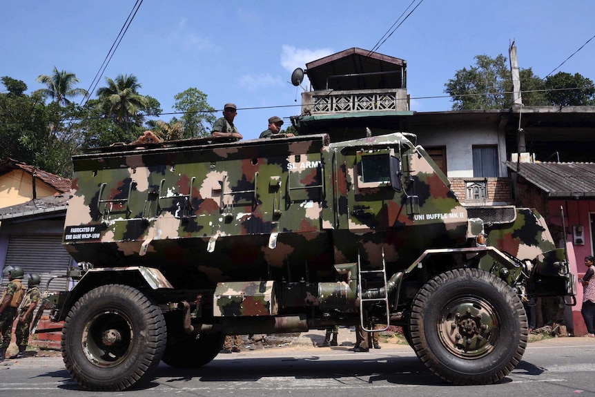 Sri Lankan army soldiers look on from an armed personnel carrier