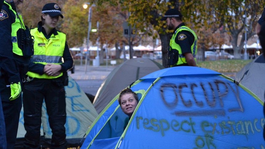 Homeless protester is woken by police during an eviction from a camp at Hobart's Parliament lawns.