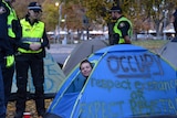 Homeless protester is woken by police during an eviction from a camp at Hobart's Parliament lawns.