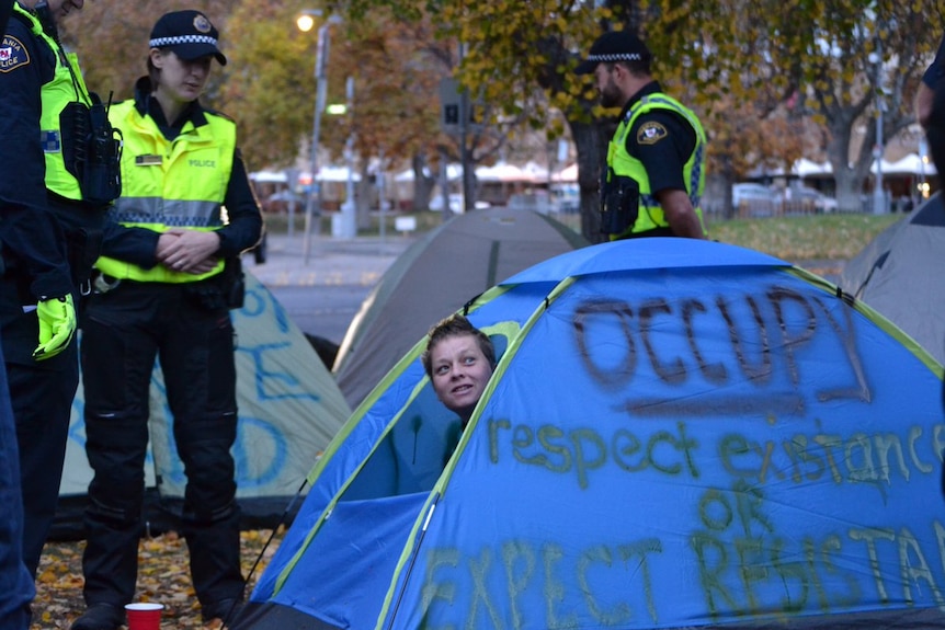 Homeless protester is woken by police during an eviction from a camp at Hobart's Parliament lawns.