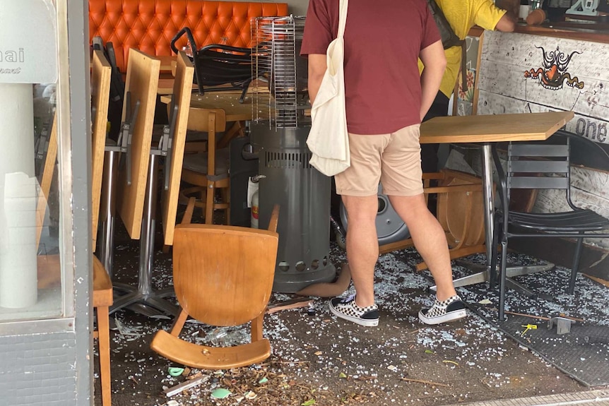 Smashed glass and fallen chairs in restaurant