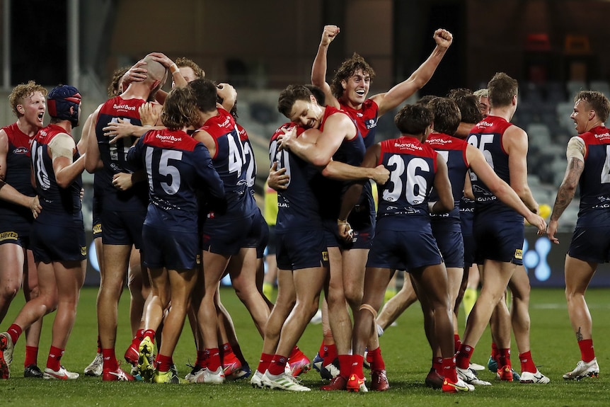 AFL players celebrating after winning a match