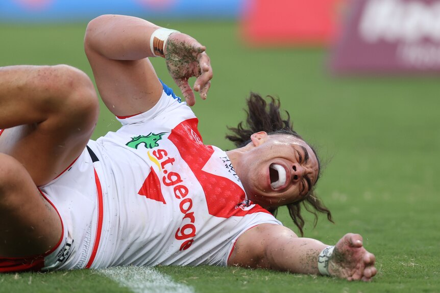 Raymond Faitala-Mariner of the Dragons shouts as he lies on the grass during an NRL game.