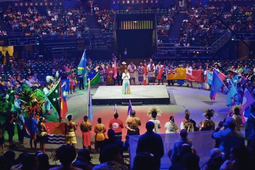 Delegates and flag-bearers gather on the floor at the FestPAC closing ceremony.
