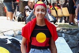 Samantha Martoo wears an Aboriginal flag headband and t-shirt.