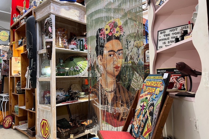 A beaded curtain depicting mexican artist frida kahlo inside an antique market.