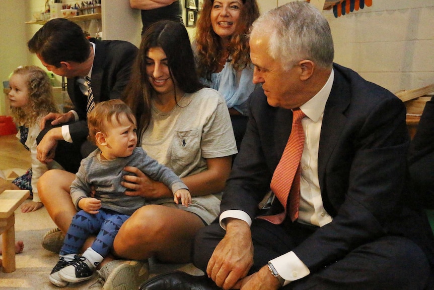 A young child appears unimpressed with Mr Turnbull