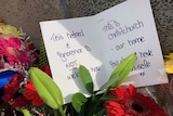 Note left with flowers at a Christchurch memorial saying "This hatred & ignorence is not welcome here".