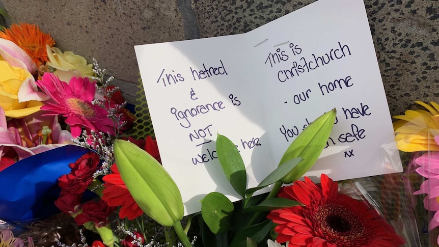 Note left with flowers at a Christchurch memorial saying "This hatred & ignorence is not welcome here".