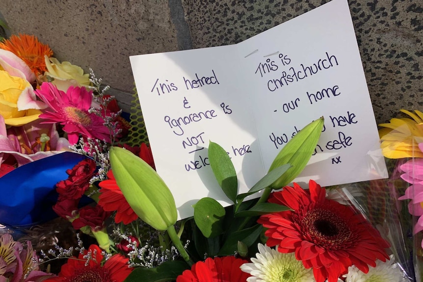 Note left with flowers at a Christchurch memorial saying "This hatred & ignorence is not welcome here".