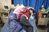 Two men asleep in a hospital bed 