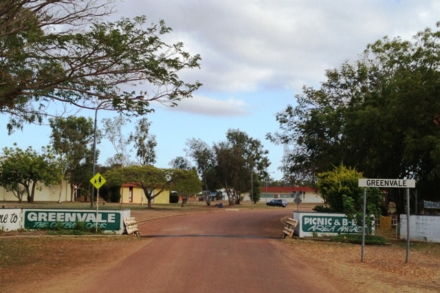 Signs at the entrance to a town on a dirt road saying Greenvale, the outback oasis.