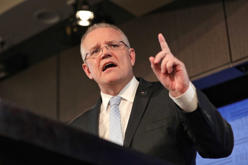 Scott Morrison points a finger in the air as he speaks at a podium