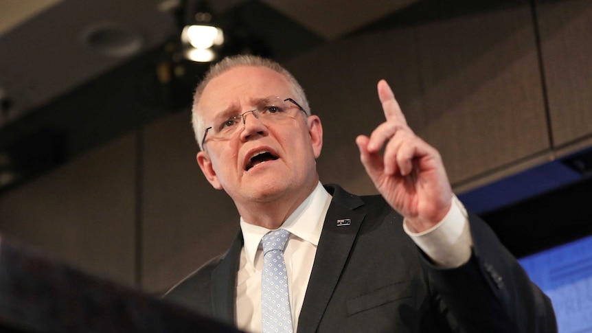 Scott Morrison points a finger in the air as he speaks at a podium