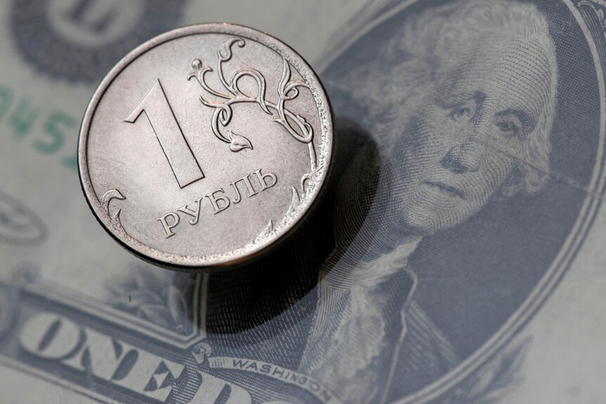 una moneda de rublo ruso descansa encima de un billete de dólar estadounidense con la cara de george washington en esta ilustración de imagen